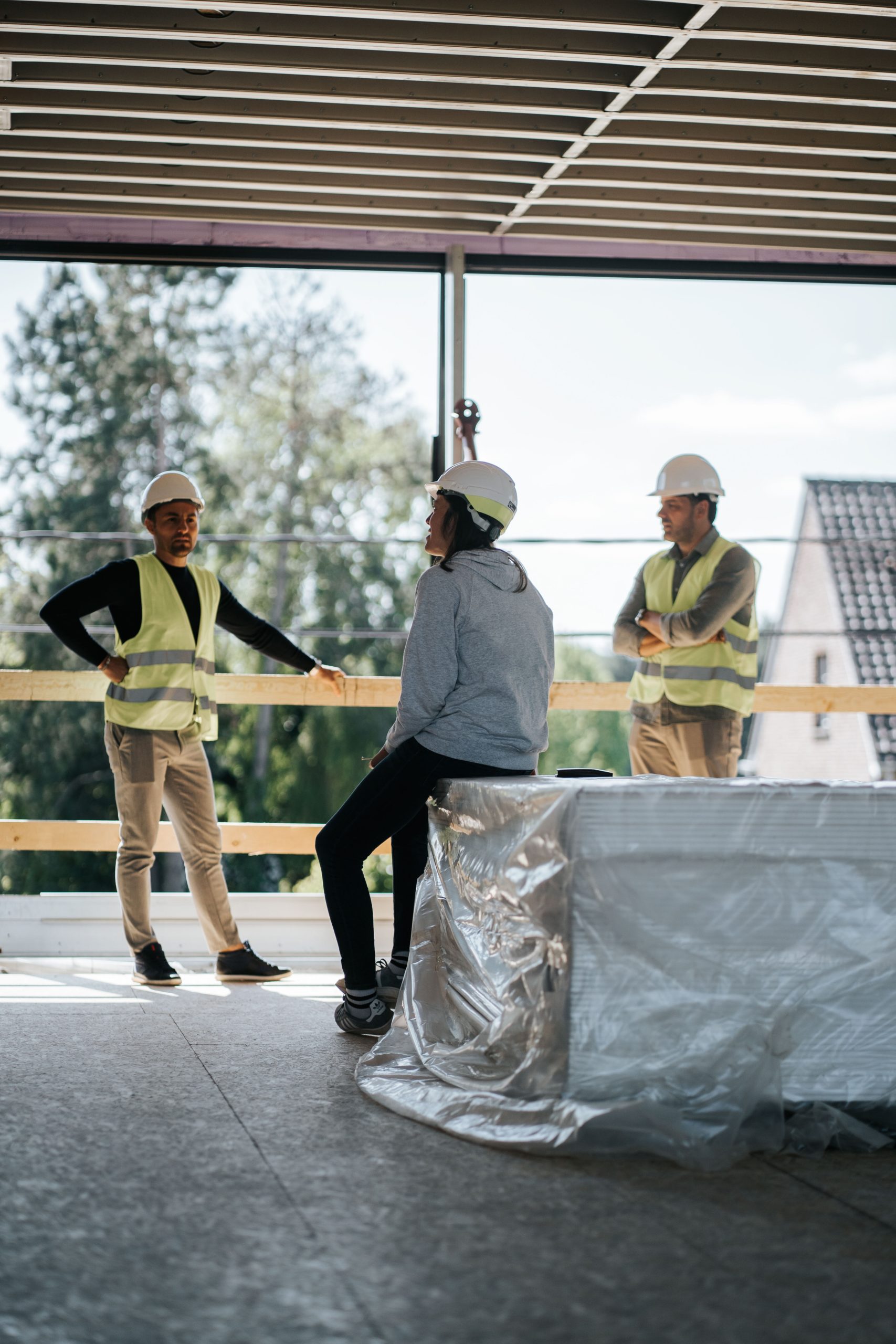 3 beSteel workers talking on site - steelframe construction site - staalframe - ossature métallique